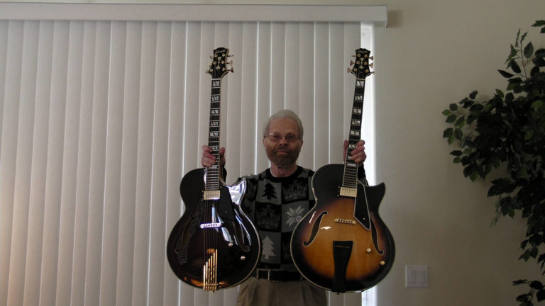 Donald Grass holding his two Conti archtop guitars