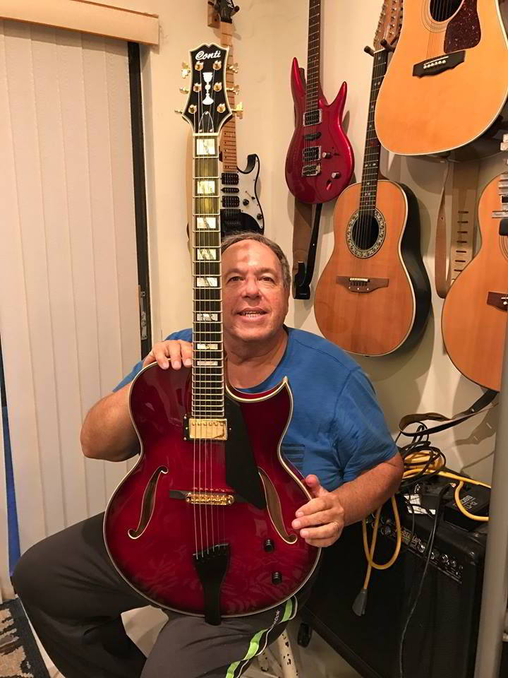 Jerry Bloch holding is new Equity Series Heirloom Conti Archtop Guitar in Ruby Red Finish