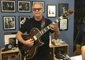 A very happy Jerry Battista poses with his new double pickup Conti Entrada Archtop Guitar in Port Wine finish