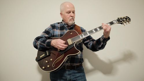 Rick White stands with his gorgeous new 15 inch double pickup Port Wine Conti Entrada jazz guitar